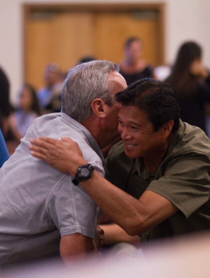 two men hugging on focus photography